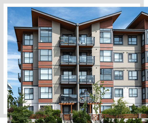 Modern apartment building with balconies and trees.