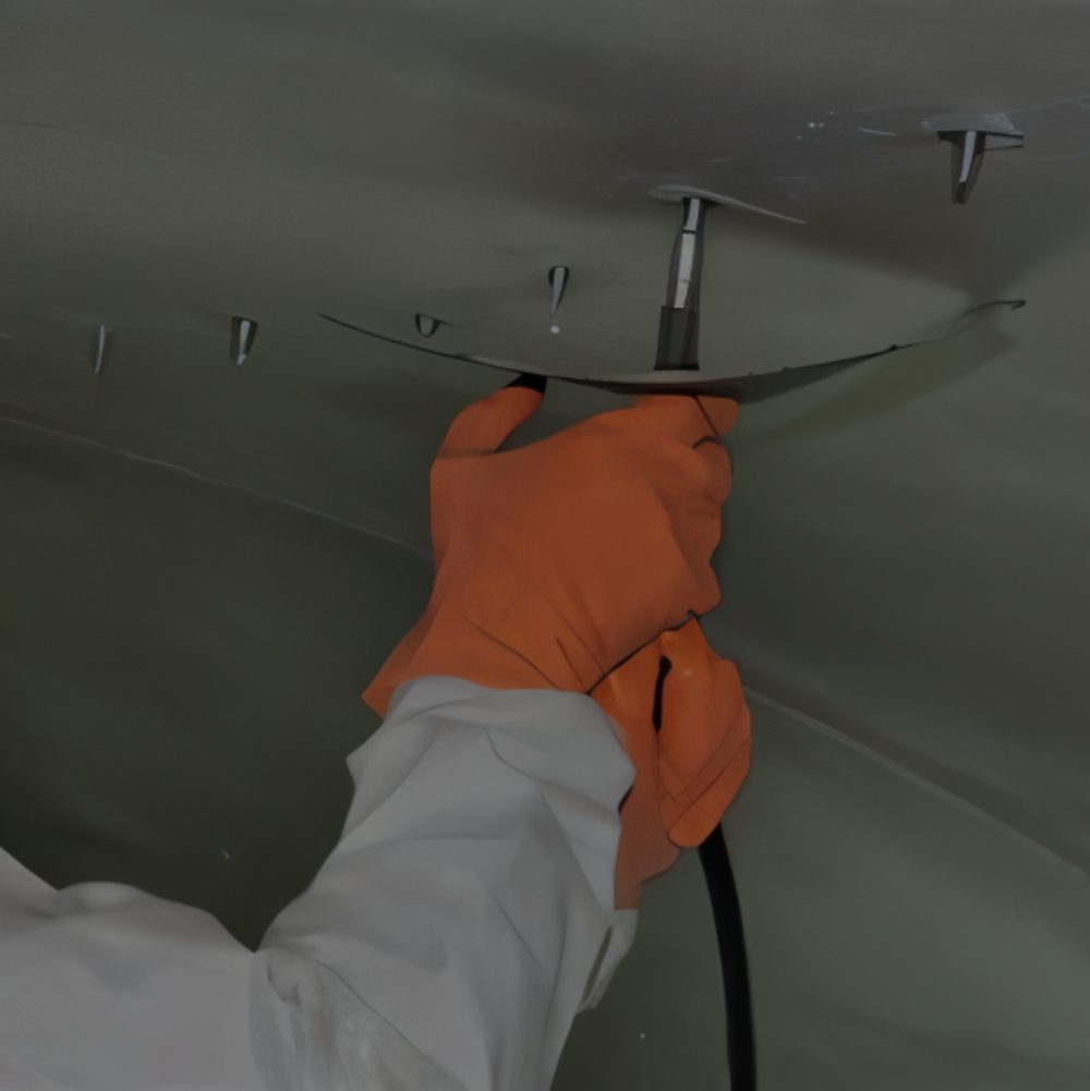 Person tightening bolt with orange gloves.