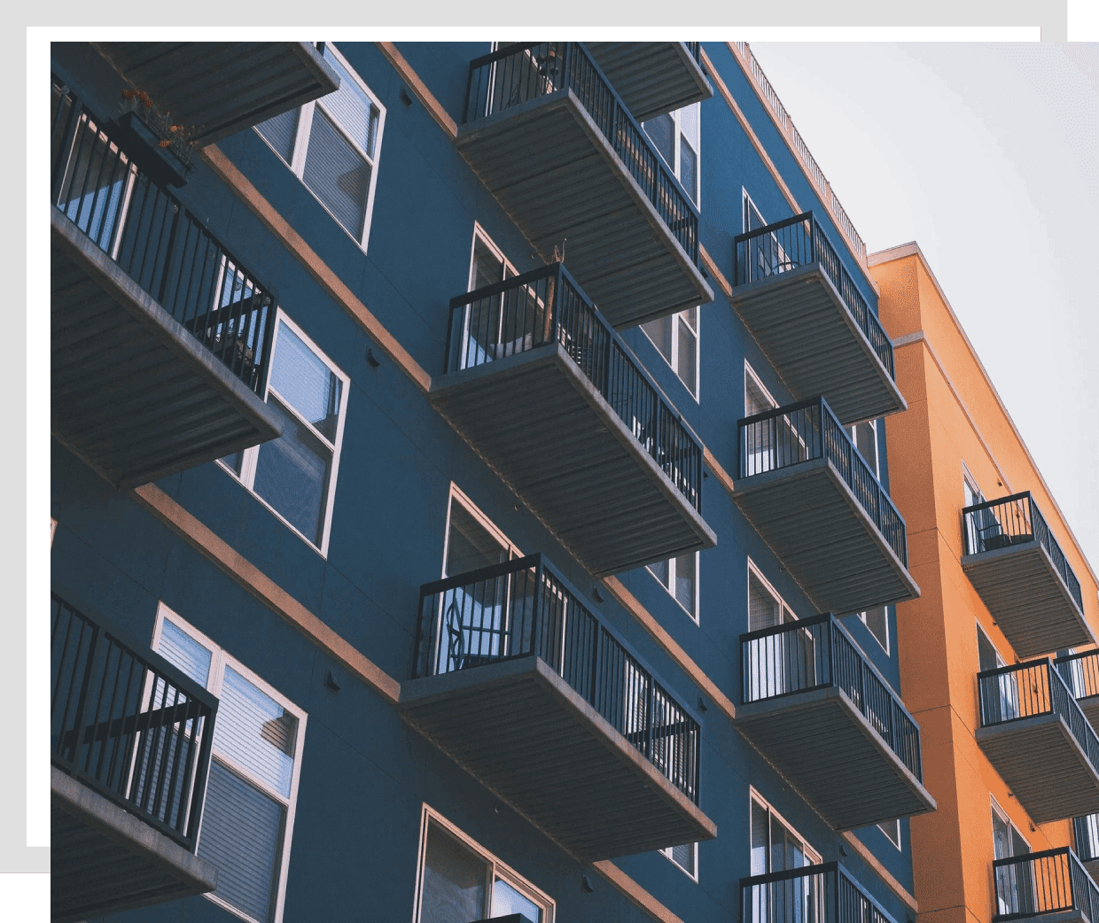 Modern apartment building with balconies and a clear sky.