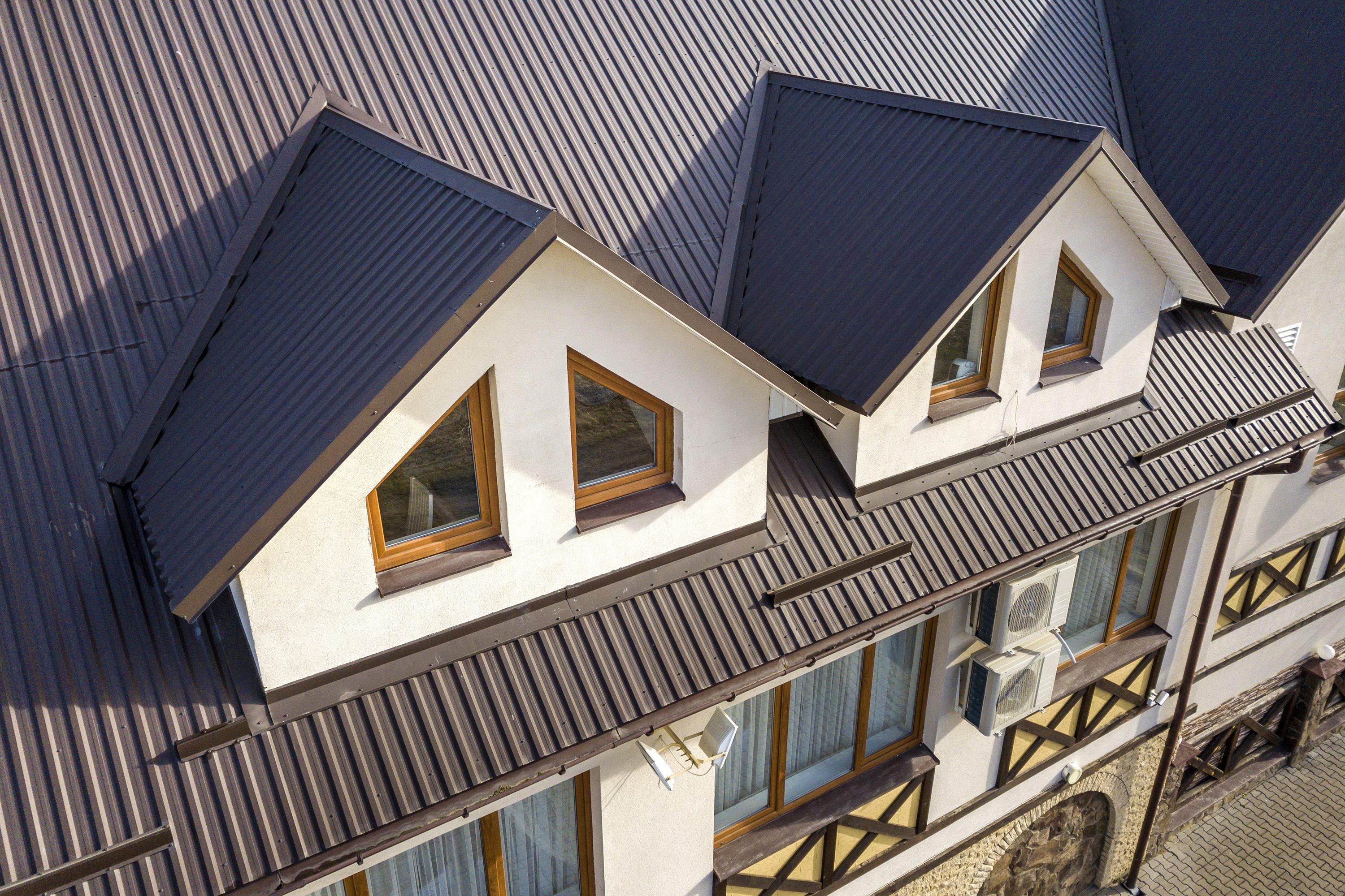 Modern house roof with two triangular dormer windows and skylights.